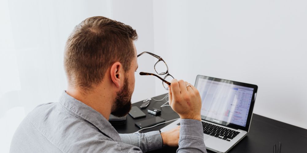 Hombre revisando información en un computador portátil.