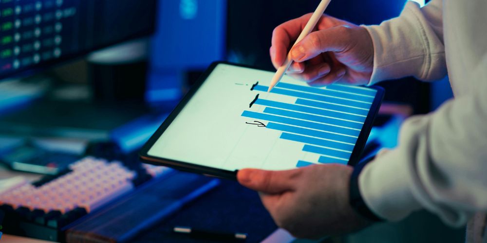 Persona señalando un gráfico de barras en una tablet con un lápiz digital.