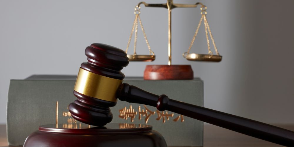 Martillo judicial junto a una balanza y libros, como representación de la justicia.