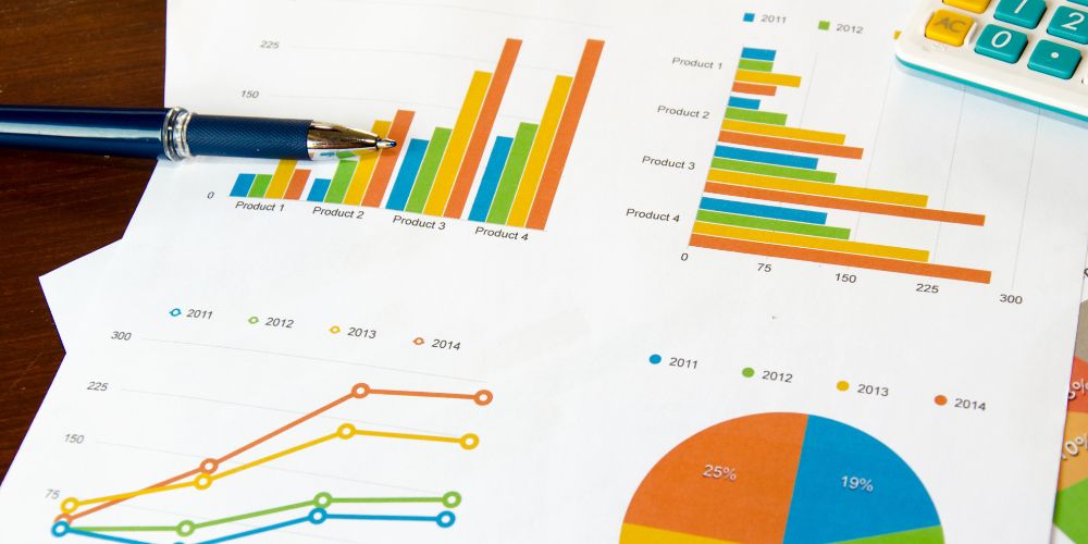 Gráficos comparativos de productos junto a un bolígrafo y una calculadora.