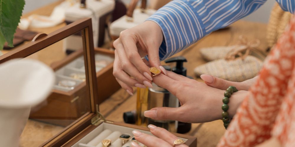 Excelente servicio al cliente y fidelización Atención al cliente en una joyería: una persona ayuda a otra a probarse un anillo.