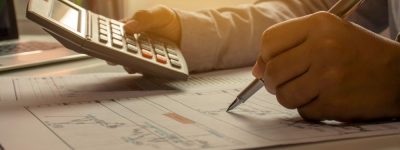 Revisión contable con calculadora, documentos y anotaciones.